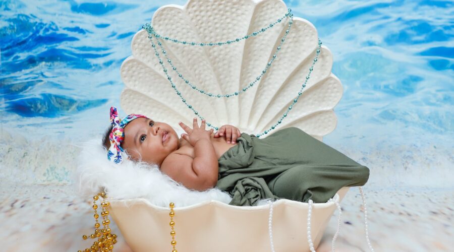 baby lying on white shell